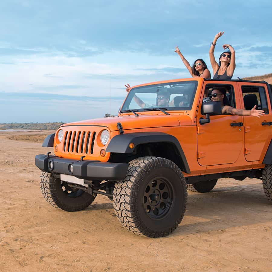 A group of people in an orange jeep